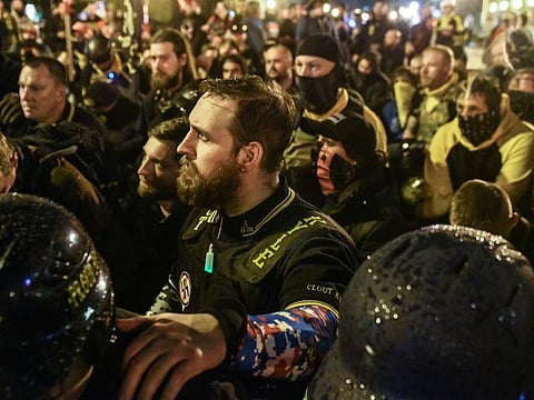 Members of the pro-Trump, far-right Proud Boys group pray for a member who was stabbed during a protest on December 12, 2020 in Washington, DC. Thousands of protesters who refuse to accept that President-elect Joe Biden won the election are rallying ahead of the electoral college vote to make Trump's 306-to-232 loss official.