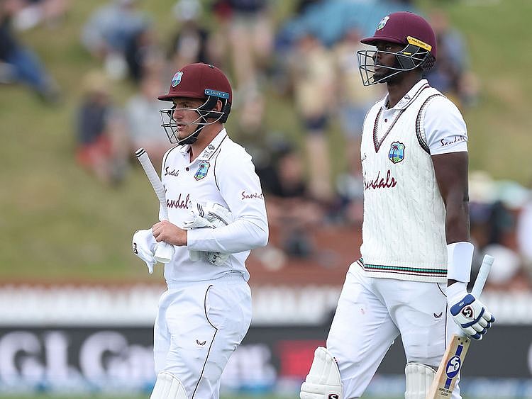 West Indies batsmen Jason Holder (R) and Joshua Da Silva leave the field as bad light stops play on day three of the second cricket Test match between New Zealand and the West Indies 