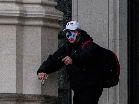 A man wearing a protective mask points his guns outside the Cathedral Church of St. John the Divine in the Manhattan borough of New York City, New York, U.S., December 13, 2020. 
