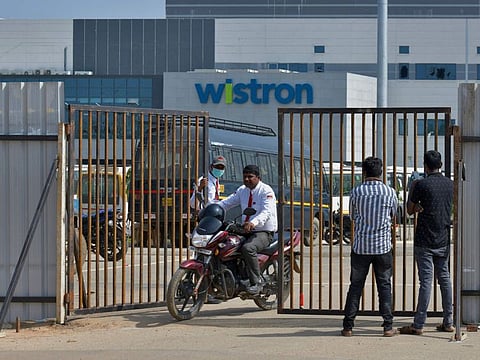 People exit from the gate of Wistron, a Taiwanese-run iPhone factory at Narsapura, about 60km from Bengaluru on December 13, 2020. 