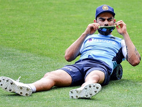 India's captain Virat Kohli does stretching exercises during a training session at Adelaide Oval on December 15, 2020, ahead of the first Test cricket match between Australia and India. 