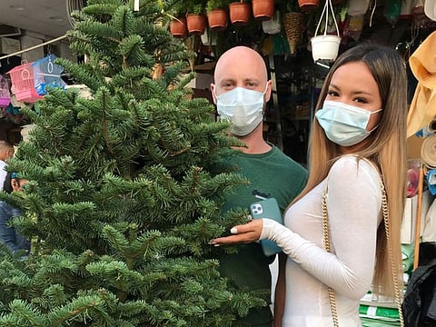 Lolita Buniaeva and Peter Ivantsov buy their Christmas tree in Satwa.