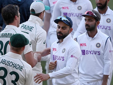 India's Virat Kohli, center, shakes hands with Australian players on the third day of their cricket test match at the Adelaide Oval. 