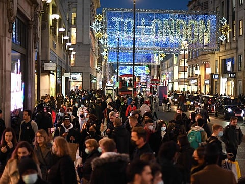 Christmas illuminations are seen above shoppers on Regent Street in the main high-street shopping area of London on December 15, 2020 ahead of fresh measures for the capital amid rising novel coronavirus infection rates. 