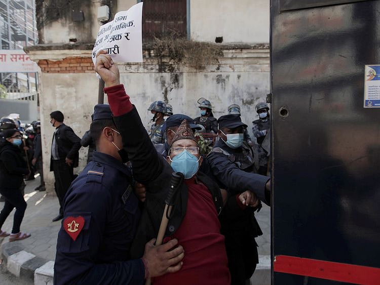 An activist affiliated with 'Human Rights and Peace Society Nepal' is detained during a protest after the parliament was dissolved and general elections were announced to be held in April and May, more than a year ahead of schedule, outside the Singha Durbar office complex that houses the Prime Minister's office and other ministries, in Kathmandu, Nepal December 21, 2020.