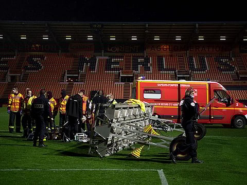 Medical staff and firemen try to rescue the groundskeeper at Lorient's stadium 