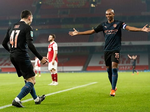 Manchester City's Phil Foden, left, celebrates with teammate Fernandinho after scoring his team's third goal.
