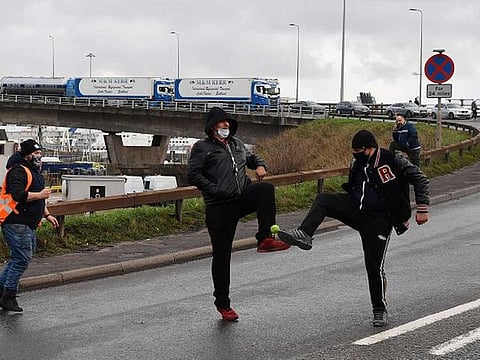 Lorry drivers play with a ball in the road leading to the entrance to the Port of Dover in Kent, south east England, on December 23, 2020, where drivers are queueing to enter after the UK and France agreed a protocol to reopen the border to accompanied freight arriving in France from the UK requiring all lorry drivers to show a negative Covid-19 test. 