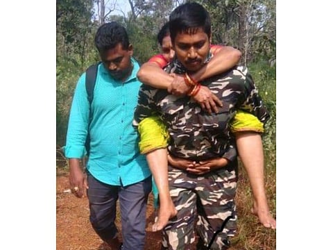 Police constable Shaikh Arshad carrying 58-year-old Nageshwaramma after she fainted during a trek to the famous Tirumala temple.
