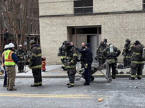 Firemen stand near damage on a street after an explosion in Nashville, Tennessee, on December 25, 2020
