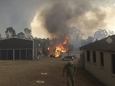 A fire is extinguished behind a house in Mollymook, New south Wales, Australia
