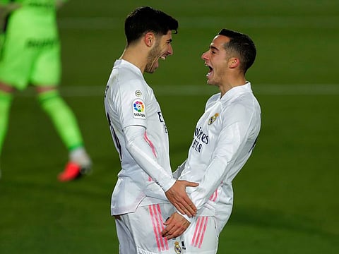 Real Madrid's Marco Asensio, left, celebrates with teammate Lucas Vazquez after scoring his side's second goal during the Spanish La Liga soccer match against Celta Vigo