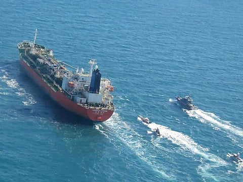 A seized South Korean-flagged tanker is escorted by Iranian Revolutionary Guard boats in the Arabian Gulf. 