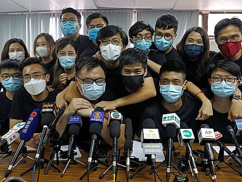 In this July 15, 2020, file photo, pro-democracy activists who were elected from unofficial pro-democracy primaries, including Joshua Wong, left, attend a press conference in Hong Kong.