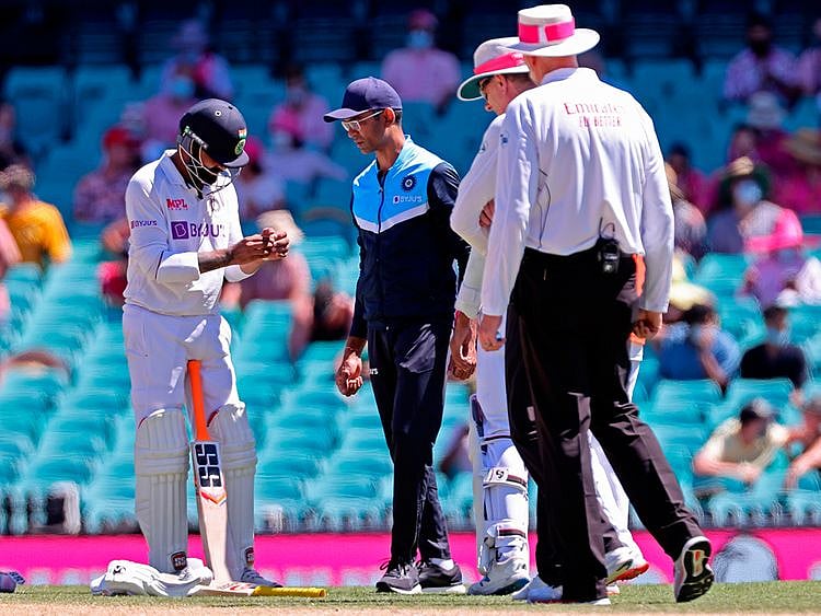 India's Ravindra Jadeja (L) holds his hand after he was hit by the ball on the third day of the third cricket Test match between Australia and India at the Sydney Cricket Ground 