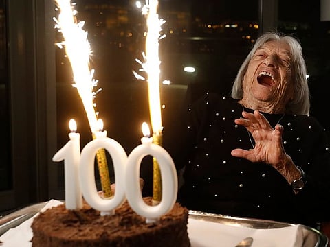 Agnes Keleti, former Olympic gold medal winning gymnast, reacts to fireworks going off on her birthday cake in Budapest, Hungary Monday Jan. 4, 2021. The oldest living Olympic champion turns 100 and says the fondest memory of her remarkable life is simply that she has lived through it all. Keleti had her illustrious career interrupted by World War II and the subsequent cancellation of the 1940 and 1944 Olympics.