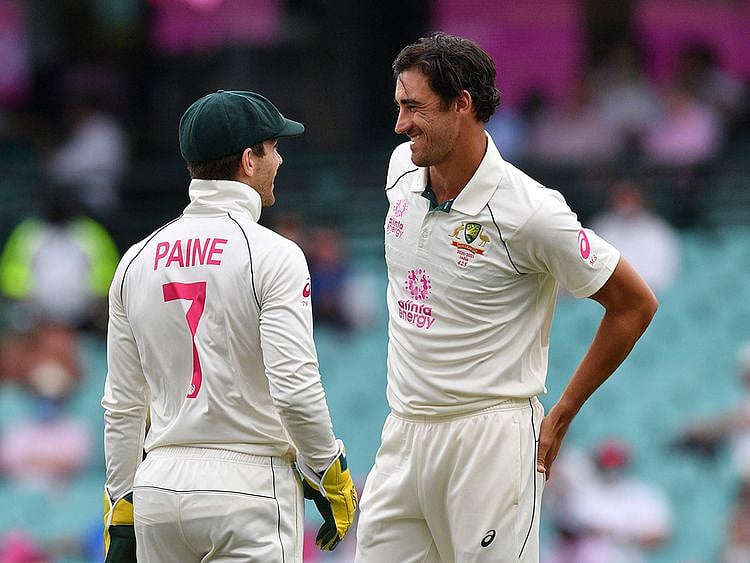 Australia's captain Tim Paine (L) speaks with Australia's Mitchell Starc 