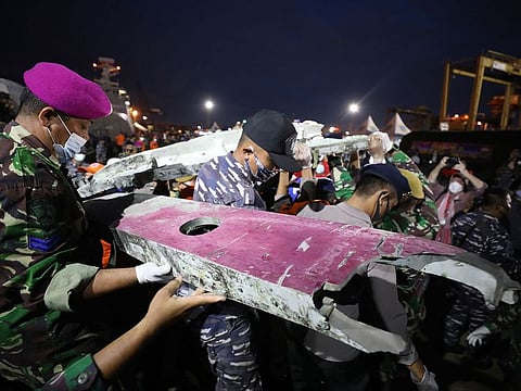 Soldiers and rescue personnel carry debris found in the waters off Java Island around where a Sriwijaya Air passenger jet crashed on Saturday, at Tanjung Priok Port in Jakarta, Indonesia.