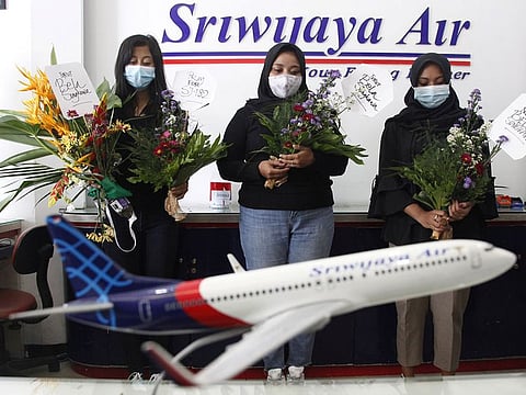 Women pray for passengers of Sriwijaya Air's flight SJ182, which crashed into the sea off the Jakarta coast, in Solo, Central Java Province, Indonesia.