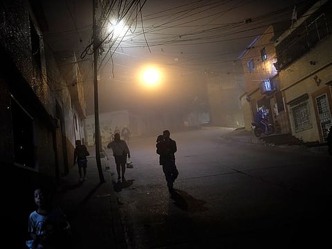 People walk on the street in the Catia neighbourhood of Caracas. [Illustrative image] 