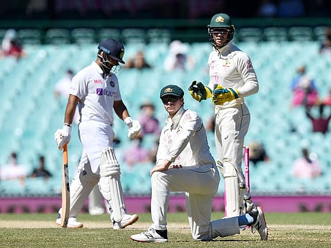 Steve Smith (C) of Australia looks on after a misfield during day five of the third Test vs India at the Sydney Cricket Ground. 