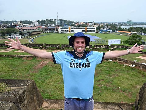 In this photo taken on January 9, 2021, English member of the Barmy Army fan group Rob Lewis, 37, gestures while posing for pictures during an interview with AFP at the ramparts of the Galle Fort overlooking Galle International Cricket Stadium, in Galle, some 180 km south of Colombo.