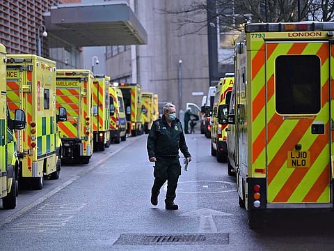 A paramedic is seen by a line of ambulances outside the Royal London Hospital in east London on January 5, 2021. 