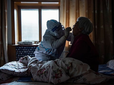 A medical worker in protective suit collects a swab from a bedridden elderly at a house during the second round of citywide nucleic acid testing following the recent coronavirus disease (COVID-19) outbreak in Shijiazhuang, Hebei province, China January 13, 2021.