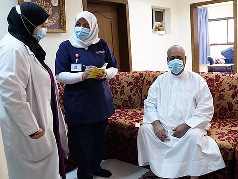 Medical teams tend to old people at a home vaccination service in Manama.