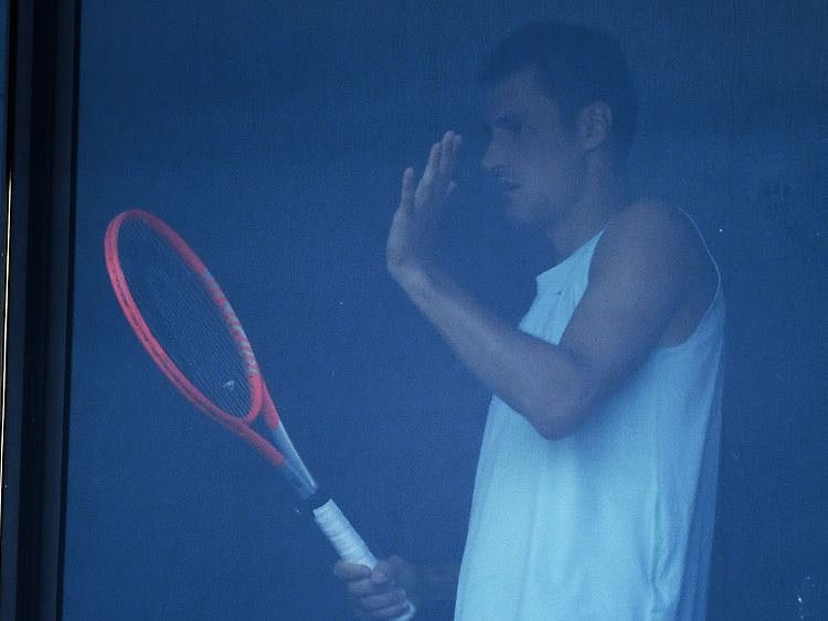 Bernard Tomic is pictured at his hotel room window