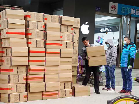 Workers move boxes of computers on a street of Wuhan in central China's Hubei province. 