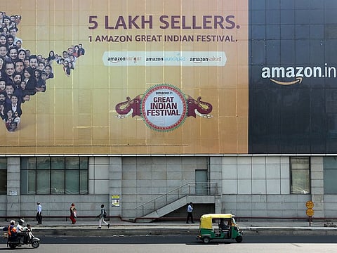 File photo: People move past a hoarding of Amazon India outside a metro rail station in New Delhi. 