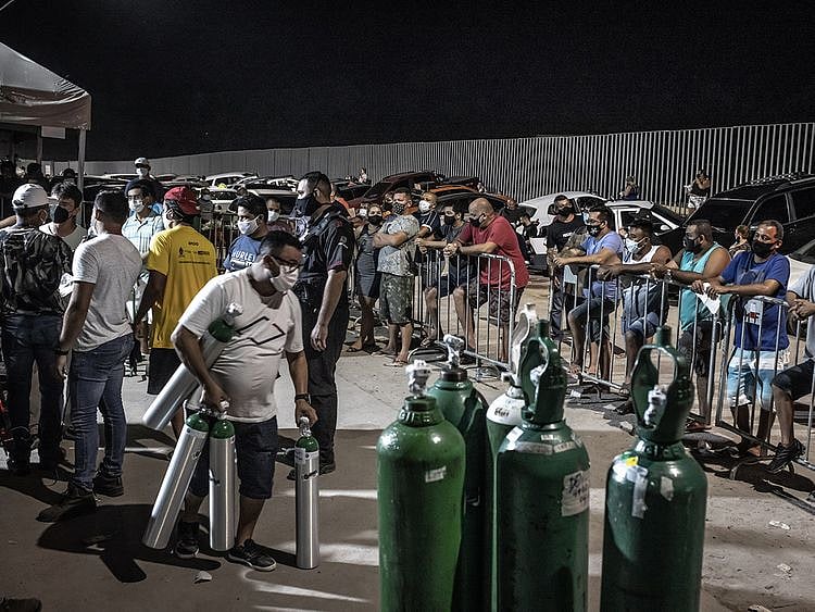People wearing protective masks wait in line to refill oxygen tanks in Manaus. 