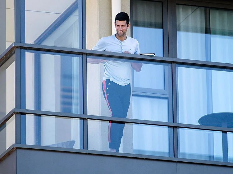Serbia's Novak Djokovic stands on the balcony at his accommodation in Adelaide, Australia.