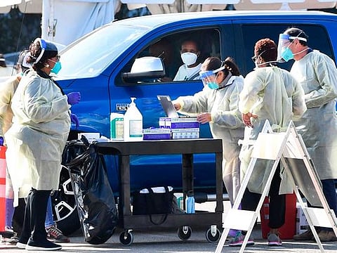 People pull up in their vehicles for COVID-19 vaccines in the parking lot of The Forum in Inglewood, California on January 19, 2021. Five large-scale vaccination sites opened throughout Los Angeles County in the fight against the coronavirus pandemic as California became the first state to top 3 million virus cases. 