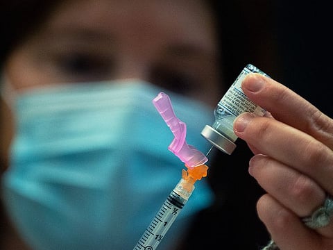A healthcare volunteer primes a syringe with the Moderna COVID-19 vaccine at Pinnacle Bank Arena in Lincoln, Nebraska. 