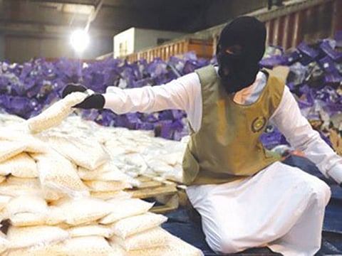 An officer sorts through the drug haul.