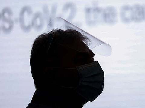 A man wearing a face mask and face shield 