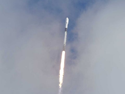 A SpaceX Falcon 9 peeks through the clouds after it lifts off on Pad 40 at Cape Canaveral Space Force Station.