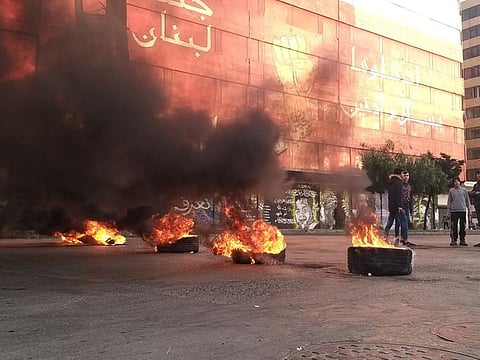 Demonstrators stand near burning tires during a protest against the lockdown and worsening economic conditions, amid the spread of COVID-19, in Tripoli, Lebanon January 25, 2021. 