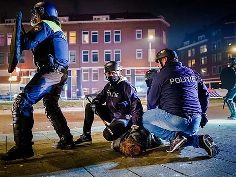 Dutch policemen arrest a man during clashes with a large group of young people on Beijerlandselaan in Rotterdam, on January 25, 2021. 