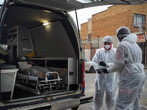 Paramedics Michael Makhethe, right, and Clive Moleso working from the Saaberie Chishty ambulance service, transfer a COVID-19 patient to the hopistal in Lenasia, South Africa, Thursday, Jan. 7, 2021. 