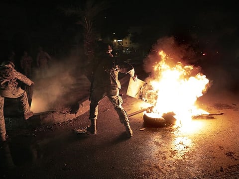 Lebanese soldiers remove tires that set on fire by protesters, during a protest against deteriorating living conditions and strict coronavirus lockdown measures, in Tripoli, Lebanon, Friday, Jannuary 29. 