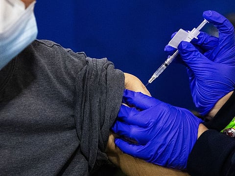 A pharmacist administers a dose of the Pfizer BioNtech COVID-19 vaccine.