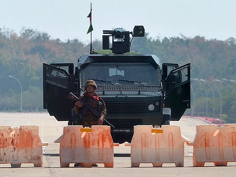 A soldier stands guard on a blockaded road to Myanmar's parliament in Naypyidaw on February 1, 2021, after the military detained the country's de facto leader Aung San Suu Kyi and the country's president in a coup. 