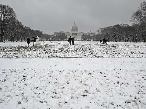People enjoy the snow dusted National Mall in Washington, DC not far from the US Capitol on January 31, 2021 as the capital region is under a winter storm warning through Monday night for an expected 12.7cm of snow. 