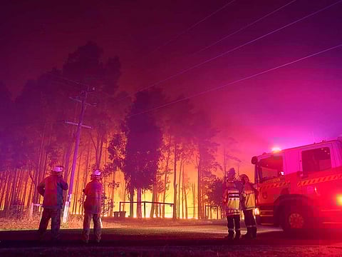 Firefighters attend a fire at Wooroloo, near Perth, Australia, Monday, Feb. 1, 2021. An out-of-control wildfire burning northeast of the Australian west coast city of Perth has destroyed an estimated 30 homes and was threatening more Tuesday, with many locals across the region told it is too late to leave. 