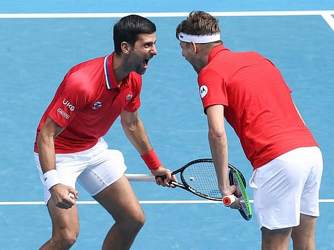 Serbia's Novak Djokovic, left, reacts with partner Filip Krajinovic after winning their ATP Cup match against Canada's Milos Raonic and Denis Shapovalov