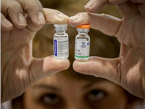 A Serbian health worker shows vials of Russian Sputnik V (L) and Chinese Sinopharm vaccines in Belgrade Fair turned into a vaccination centre, on February 1, 2021.  