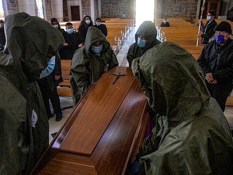 Frontliners transport the coffin of a Lebanese Christian woman who died of the COVID-19 disease.